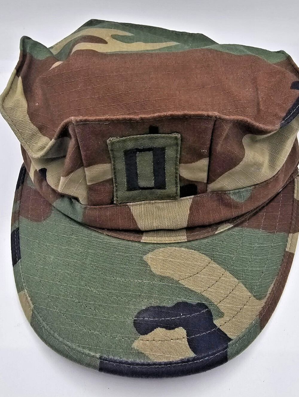 US Military Woodland Camouflage Utility Cap with a Captain's rank insignia